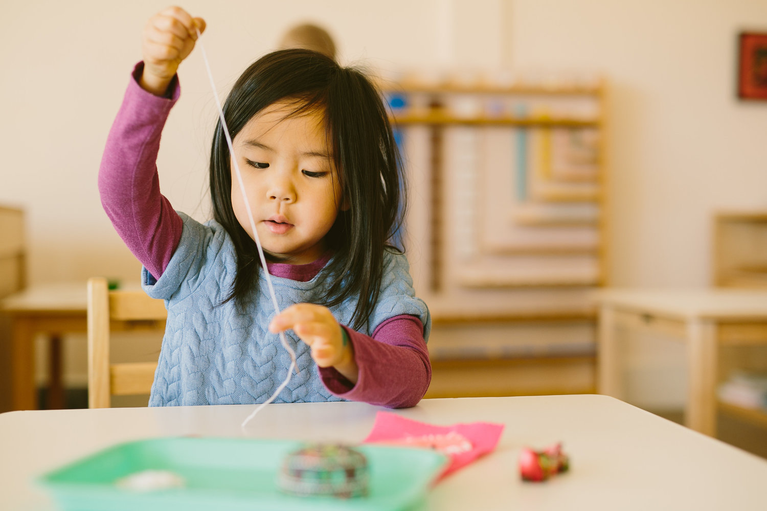 Une petite fille manipule du matériel Montessori